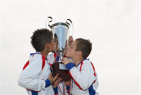 preteen kissing - Soccer Players Kissing Trophy Foto de stock - Sin royalties Premium, Código: 600-01374827