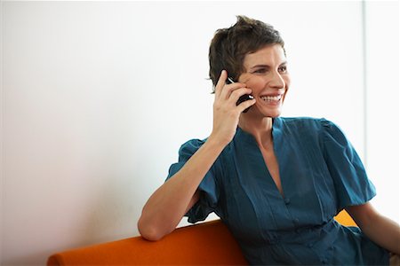 Woman with Cellular Phone on Sofa Stock Photo - Premium Royalty-Free, Code: 600-01464402