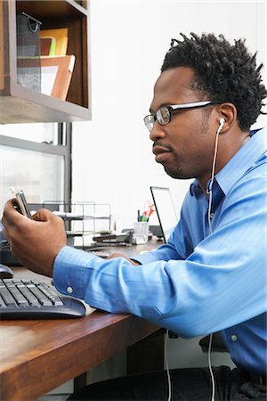 Man listening to music in office Stock Photo - Premium Royalty-Free, Code: 600-01614879