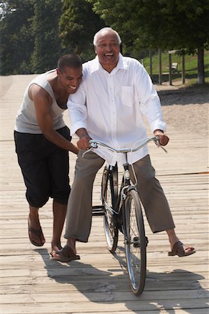 simsearch:600-02348915,k - Père de fils poussant la bicyclette Photographie de stock - Premium Libres de Droits, Code: 600-01616628
