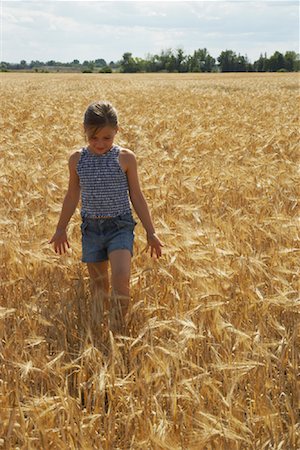 Girl Walking through Grain Field Stock Photo - Premium Royalty-Free, Code: 600-01716056