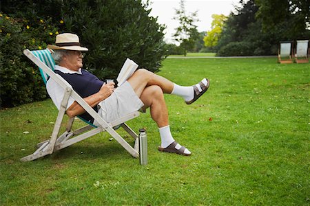 retired sock sandals - Man Sitting in Lawn Chair, Reading Book Foto de stock - Sin royalties Premium, Código: 600-01717986