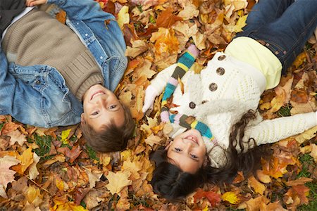 Children Lying in Autumn Leaves Foto de stock - Sin royalties Premium, Código: 600-01742503