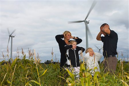 Family Covering Ears near Wind Turbines, Denmark Stock Photo - Premium Royalty-Free, Code: 600-01764379