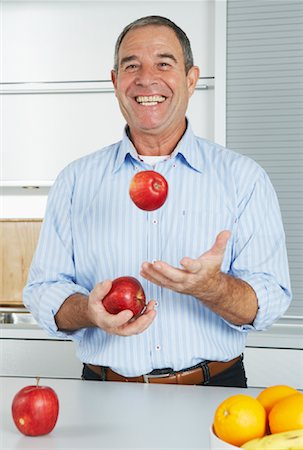 Man Juggling Apples in Kitchen Stock Photo - Premium Royalty-Free, Code: 600-01764534