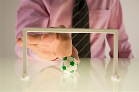 simsearch:700-00035072,k - Businessman Playing With Miniature Football Stock Photo - Premium Royalty-Free, Code: 600-01790107