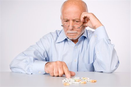 Man Looking at Pills Foto de stock - Sin royalties Premium, Código: 600-01954285