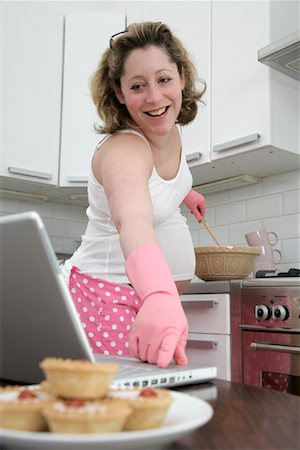 Femme enceinte de cuisson dans la cuisine avec ordinateur portable Photographie de stock - Premium Libres de Droits, Code: 600-02010379