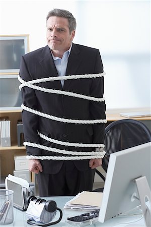 simsearch:400-04041701,k - Businessman Tied Up with Rope at Desk Stock Photo - Premium Royalty-Free, Code: 600-02081765