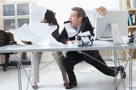 Business People Trying to Hold onto Paperwork Blowing Around on Desk Stock Photo - Premium Royalty-Free, Code: 600-02081779