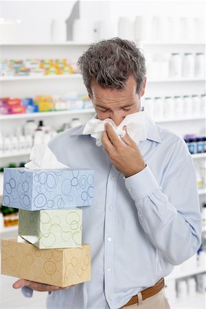 picture of cough and cold person - Man in Pharmacy Blowing Nose, Carrying Boxes of Tissue Stock Photo - Premium Royalty-Free, Code: 600-02245663