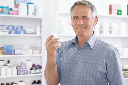 pill bottles - Portrait of Man in Pharmacy Holding Bottle of Pills Stock Photo - Premium Royalty-Free, Code: 600-02245681