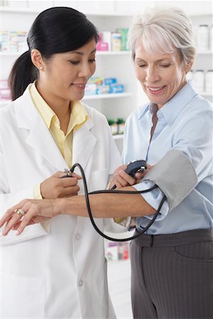 Pharmacist Checking Client's Bloodpressure Stock Photo - Premium Royalty-Free, Code: 600-02265352