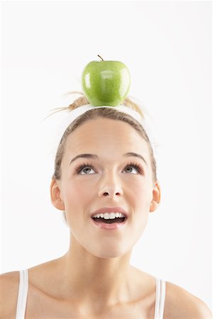 Portrait de jeune femme à la pomme sur la tête Photographie de stock - Premium Libres de Droits, Code: 600-02312464
