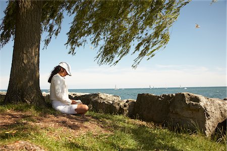 Woman Reading a Book Underneath a Willow Tree, Sailboats on Lake Ontario in the Background Stock Photo - Premium Royalty-Free, Code: 600-02347809