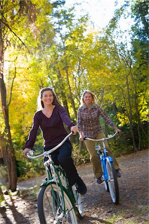 simsearch:700-01837370,k - Two Women Riding Bicycles through Forest Stock Photo - Premium Royalty-Free, Code: 600-02386116