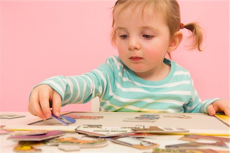 putting the pieces together - Little Girl Doing a Puzzle Stock Photo - Premium Royalty-Free, Code: 600-02660145