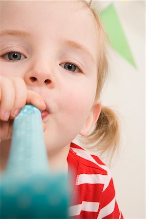 Little Girl Blowing a Noisemaker at a Birthday Party Stock Photo - Premium Royalty-Free, Code: 600-02660154
