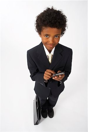 Little Boy Dressed Up as a Businessman Using Cell Phone Stock Photo - Premium Royalty-Free, Code: 600-02693726