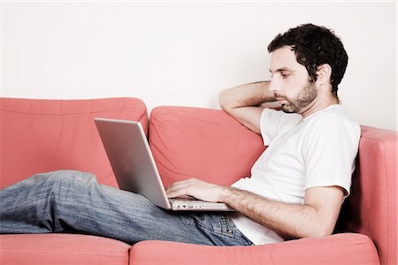 Young Man with Laptop on Sofa Stock Photo - Premium Royalty-Free, Code: 600-02701084