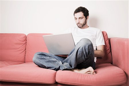 simsearch:600-02756616,k - Young Man with Laptop on Sofa Foto de stock - Sin royalties Premium, Código: 600-02701085