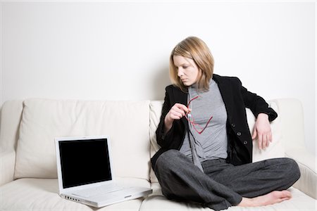 single young woman sitting on sofa with laptop - Businesswoman on Sofa with Laptop Foto de stock - Sin royalties Premium, Código: 600-02786749