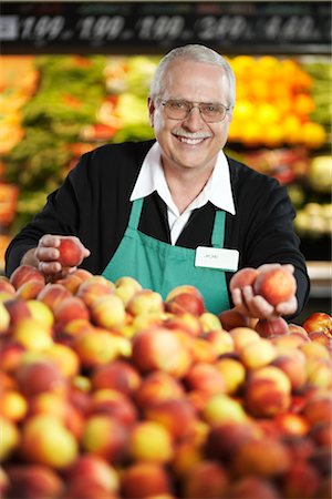 photo of grocery clerk - Organisation des pêches dans l'allée des produits commis d'épicerie Photographie de stock - Premium Libres de Droits, Code: 600-02912448