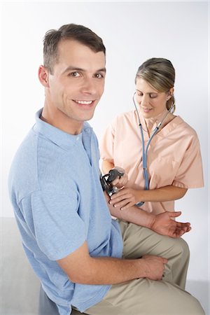 simsearch:600-02912811,k - Nurse Testing Man's Blood Pressure Stock Photo - Premium Royalty-Free, Code: 600-02912831