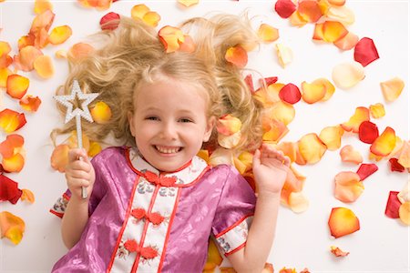 simsearch:600-03692097,k - Little Girl with Magic Wand Lying Amongst Flower Petals Stock Photo - Premium Royalty-Free, Code: 600-03005089