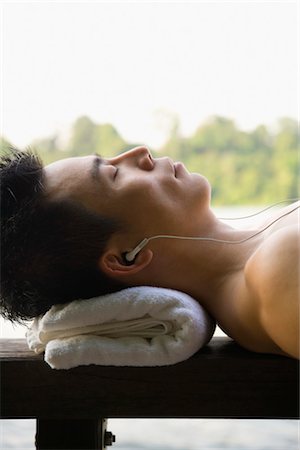 Man Lying Down and Listening to MP3 Player Stock Photo - Premium Royalty-Free, Code: 600-03333281