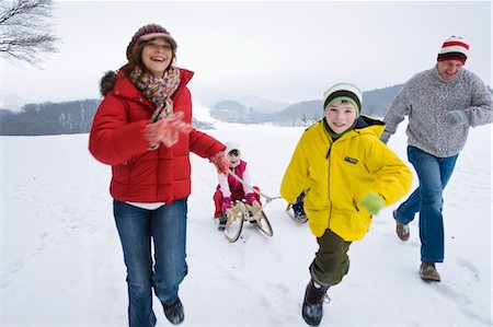 Parents and Brother Pulling Girl in Sled in Winter Stock Photo - Premium Royalty-Free, Code: 600-03406316