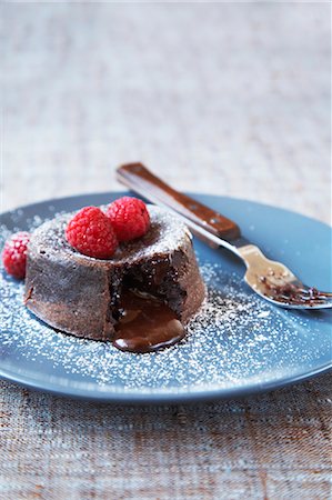 Chocolate Lava Cake with Raspberries and Icing Sugar Stock Photo - Premium Royalty-Free, Code: 600-03445423