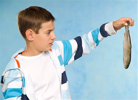 Boy Holding Dead Fish Foto de stock - Sin royalties Premium, Código: 600-03456222