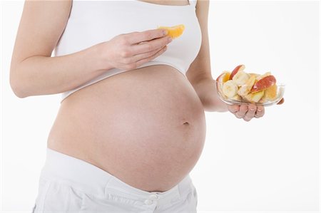 Pregnant Woman Eating Fruit Foto de stock - Sin royalties Premium, Código: 600-03451337