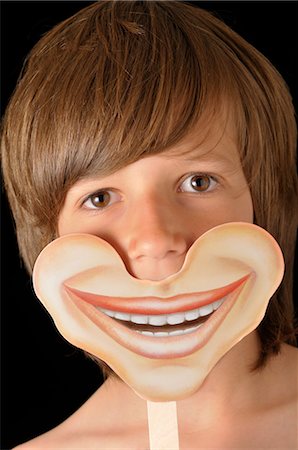 simsearch:600-03230190,k - Boy Holding Smiling Mask Fotografie stock - Premium Royalty-Free, Codice: 600-03587141