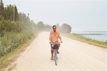 Man Riding Bike, Clearwater Lake Provincial Park, Manitoba, Canada Stock Photo - Premium Royalty-Free, Code: 600-03641267