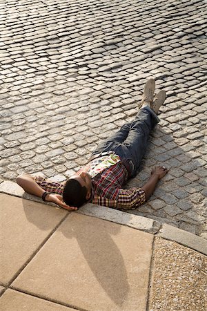 fashions men urban - Man Laying Down on Road Stock Photo - Premium Royalty-Free, Code: 600-03692072