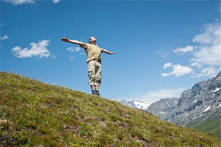Man Standing on Mountain Side with Arms Outstretched, Bernese Oberland, Switzerland Stock Photo - Premium Royalty-Free, Code: 600-03907144