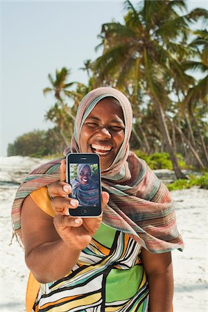 Woman Showing Snapshots, Nyota Beach, Unguja, Zanzibar, Tanzania Stock Photo - Premium Royalty-Free, Code: 600-03907372