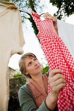 Woman hanging laundry on clothesline Stock Photo - Premium Royalty-Free, Code: 614-05556668