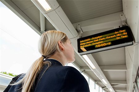 people waiting at train station - Businesswoman looking at departure board in station Stock Photo - Premium Royalty-Free, Code: 614-05556690