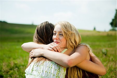 simsearch:614-05557077,k - Young women embracing in a field Stock Photo - Premium Royalty-Free, Code: 614-05557087