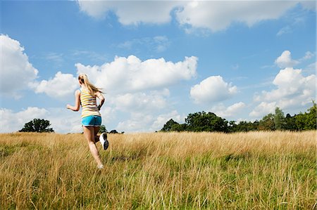 simsearch:614-05557077,k - Young woman jogging through a field on a sunny day Stock Photo - Premium Royalty-Free, Code: 614-05557100
