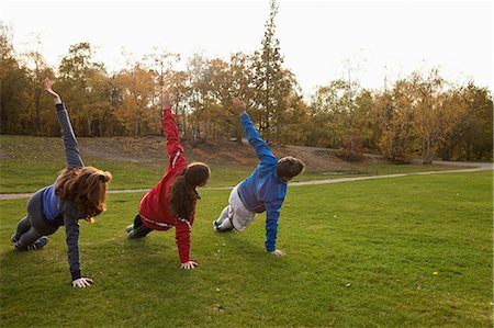 stretching exercise - Three young friends stretching on grass in park Foto de stock - Sin royalties Premium, Código: 614-05662251