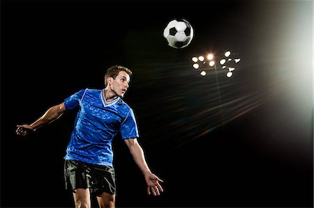 Young man leaping to head soccer ball Stock Photo - Premium Royalty-Free, Code: 614-05662283