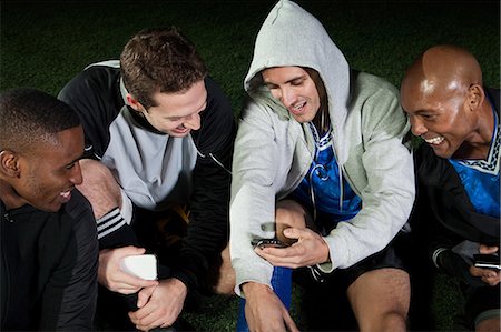 practicing - Soccer players looking at cellphone on pitch Stock Photo - Premium Royalty-Free, Code: 614-05662297