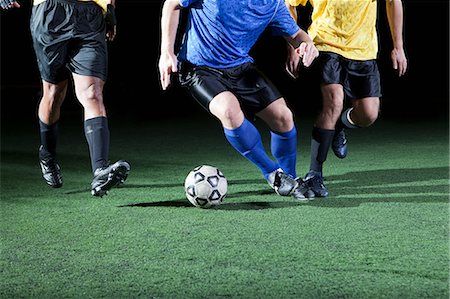 football skill - Soccer players tackling on pitch, low section Stock Photo - Premium Royalty-Free, Code: 614-05792055