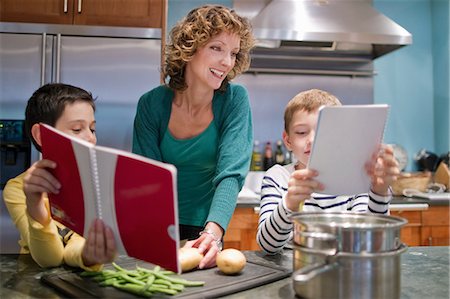 family computer kitchen - Mid adult woman cooking in kitchen with sons Stock Photo - Premium Royalty-Free, Code: 614-05792275