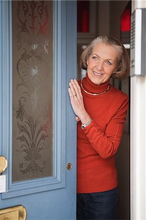 front door - Senior woman opening front door Stock Photo - Premium Royalty-Free, Code: 614-05792328