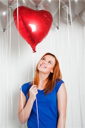 string (not clothing, packaging or instruments) - Young woman holding a heart shaped balloon Stock Photo - Premium Royalty-Free, Code: 614-05792507